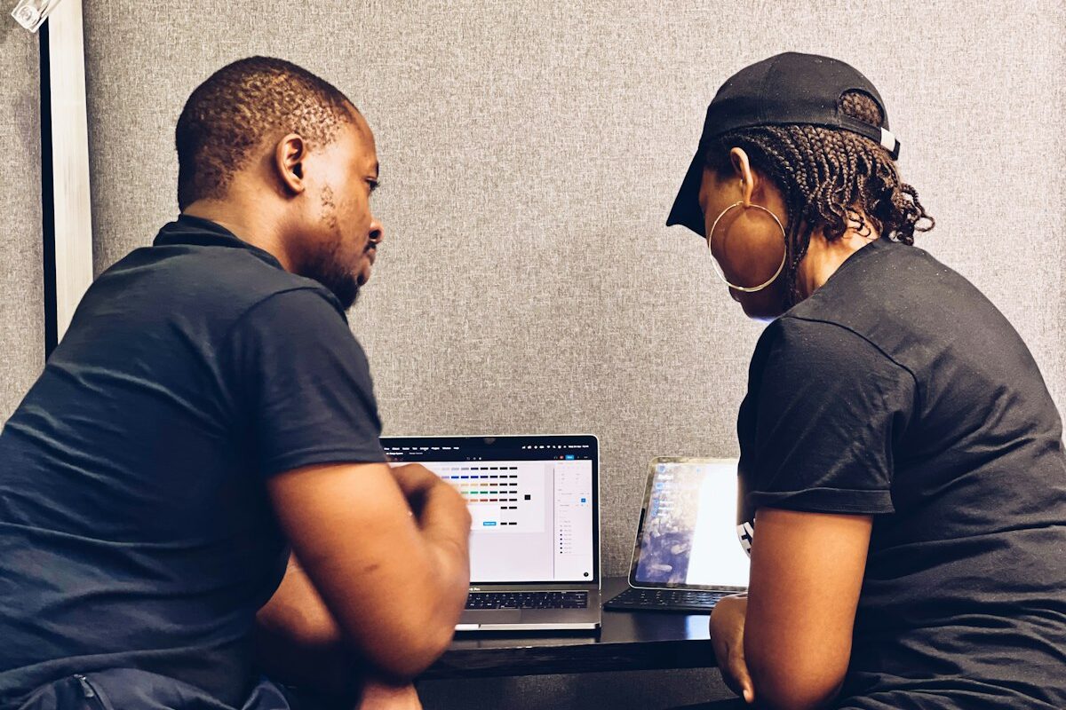 Two colleagues looking at a laptop screen together