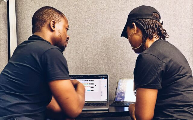 Two colleagues looking at a laptop screen together