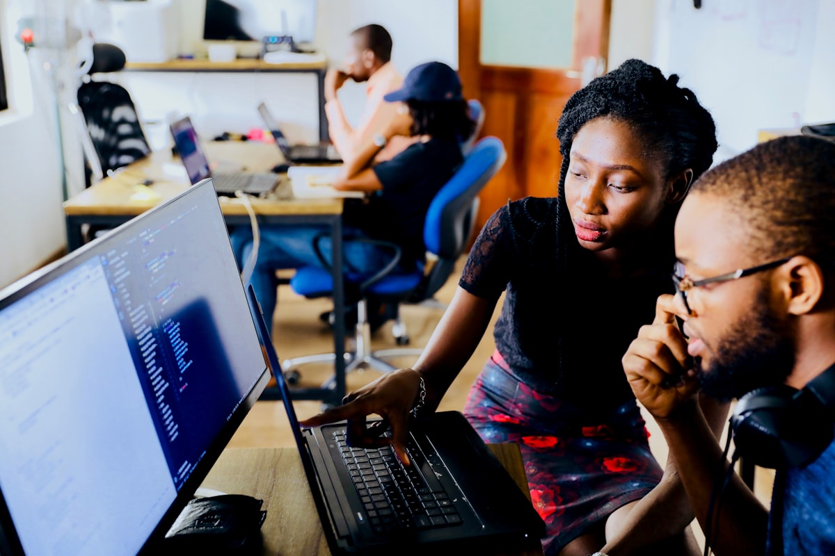 Colleagues reviewing code on a computer screen together