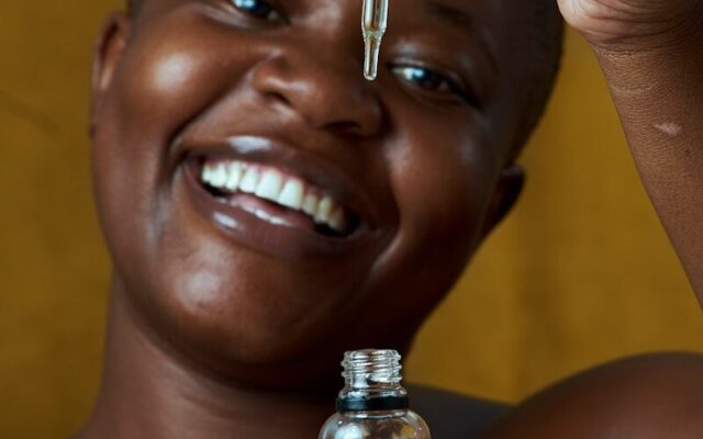 African woman holding a cosmetics skincare product jar in Kenya