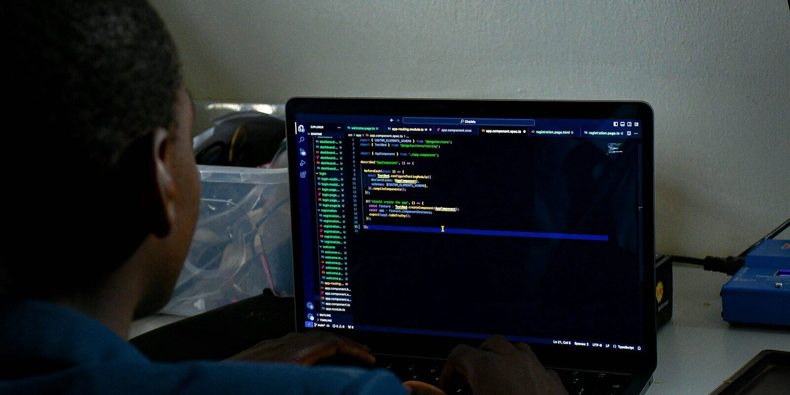 A software developer working on a laptop, representing the technical compliance work an outsourced data protection officer oversees under Kenya's Data Protection Act.