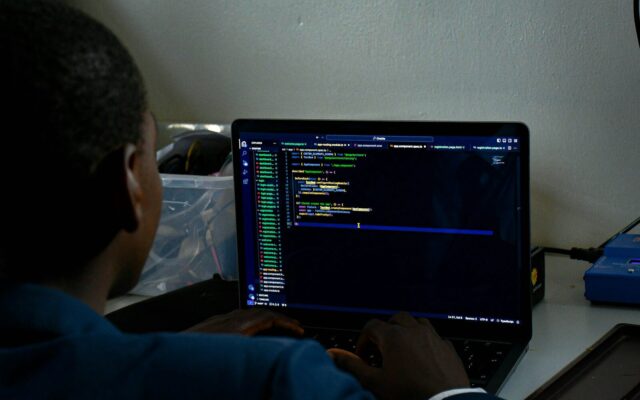 A software developer working on a laptop, representing the technical compliance work an outsourced data protection officer oversees under Kenya's Data Protection Act.