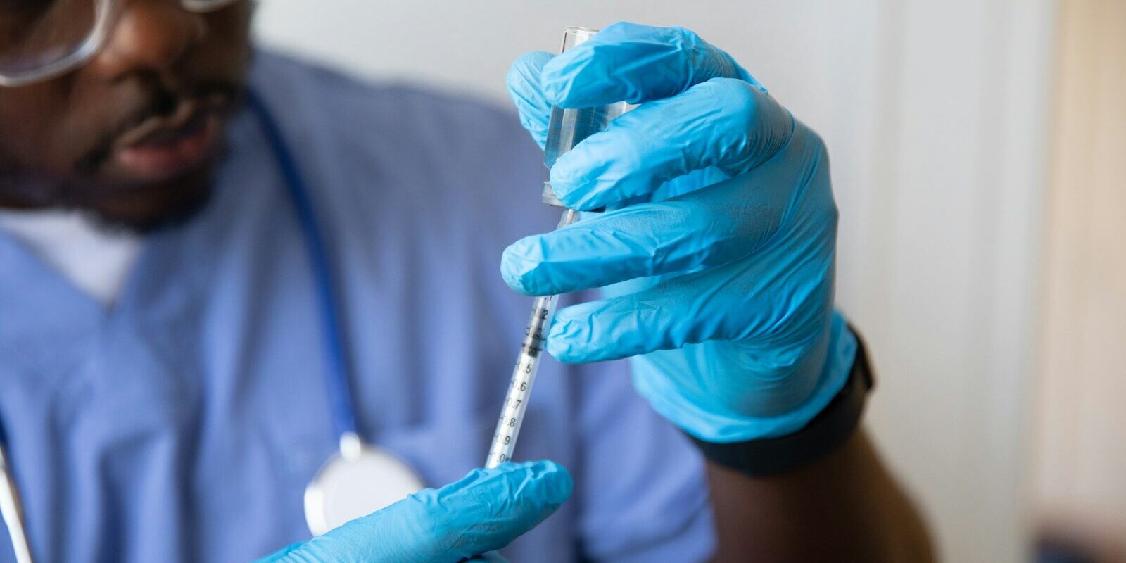 African healthcare worker preparing a vaccine dose, representing local pharmaceutical manufacturing capacity in Kenya