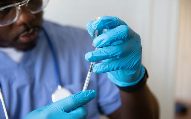 African healthcare worker preparing a vaccine dose, representing local pharmaceutical manufacturing capacity in Kenya