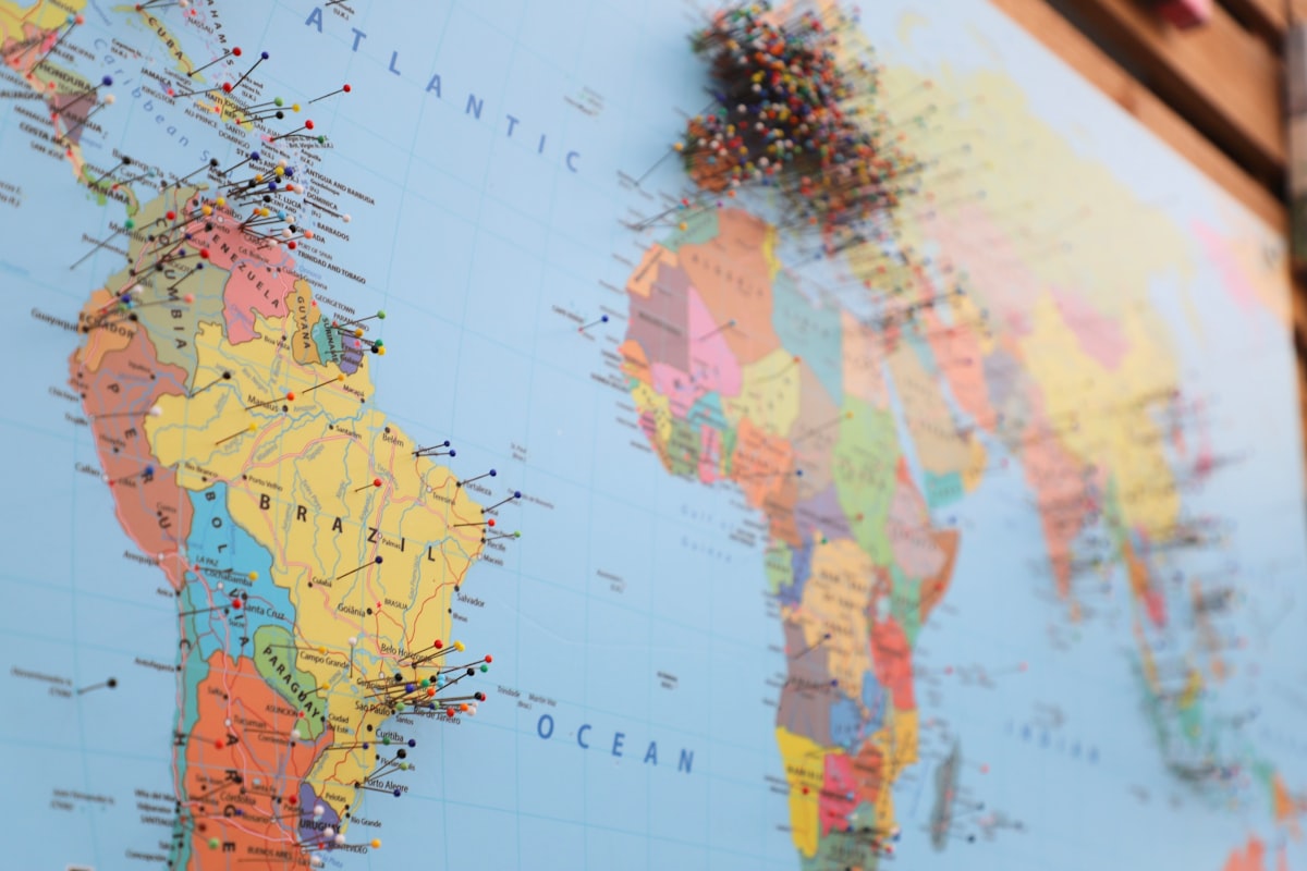 A world map with coloured pins marking locations