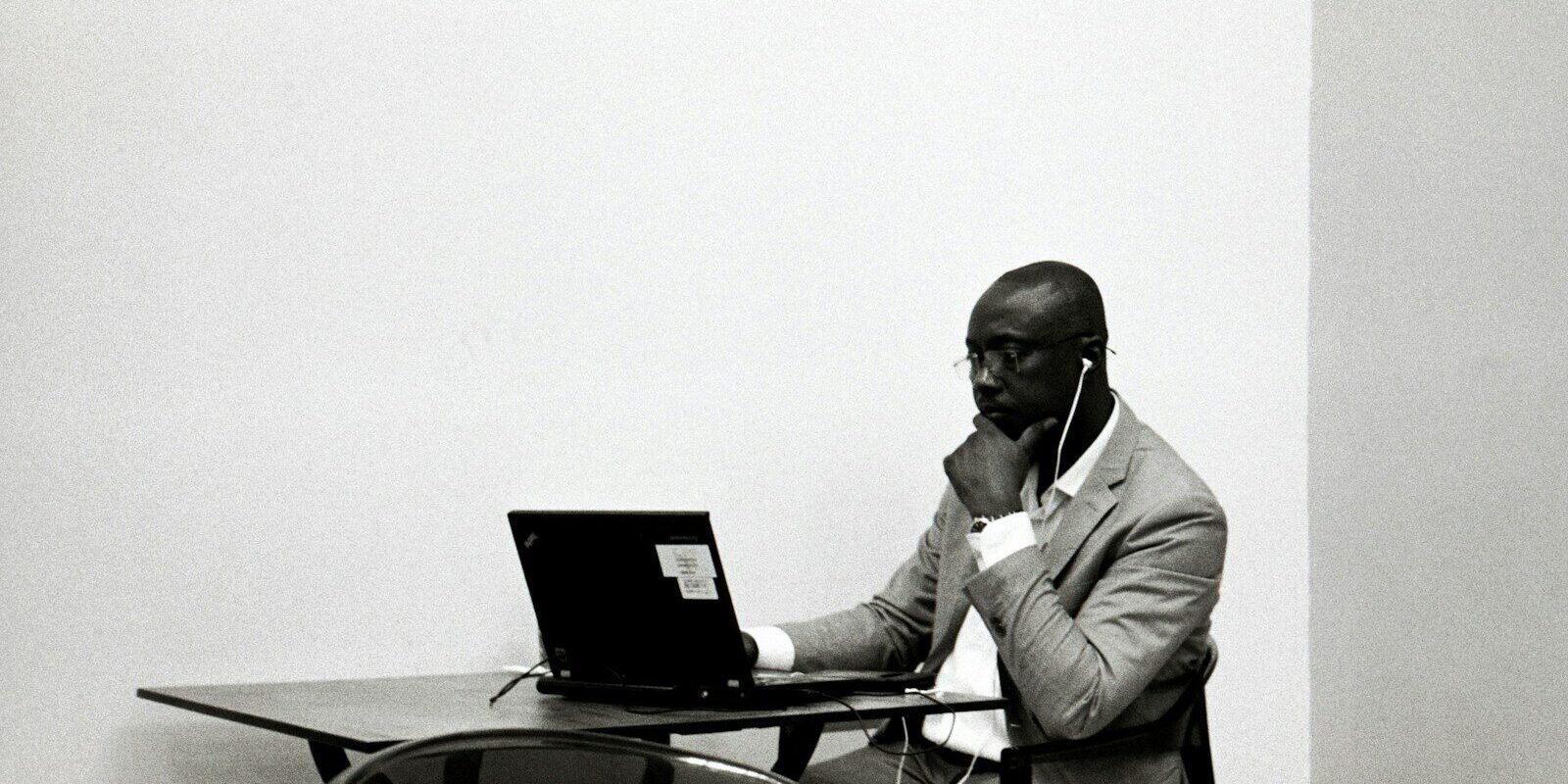 Employee working alone at a desk on a laptop during an evening shift, representing night roster employment in Kenya