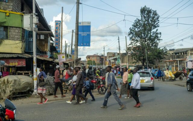 Pedestrians and motorbikes on a busy Kenyan street, illustrating life as a resident in Kenya for tax residence purposes