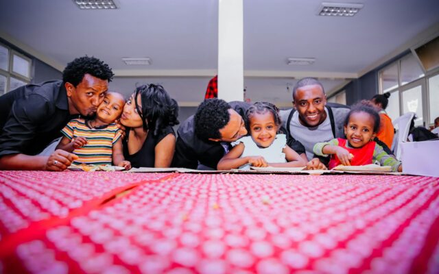 African parents and young children sharing a meal together at a table, illustrating appointing a guardian for minor children in Kenya