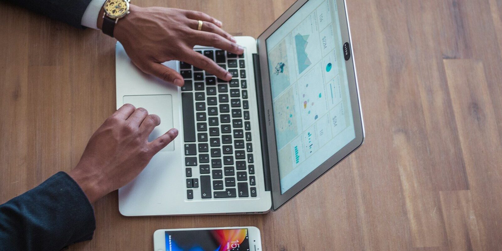 Hands typing on a laptop with a phone on the desk, illustrating an online Class N permit application