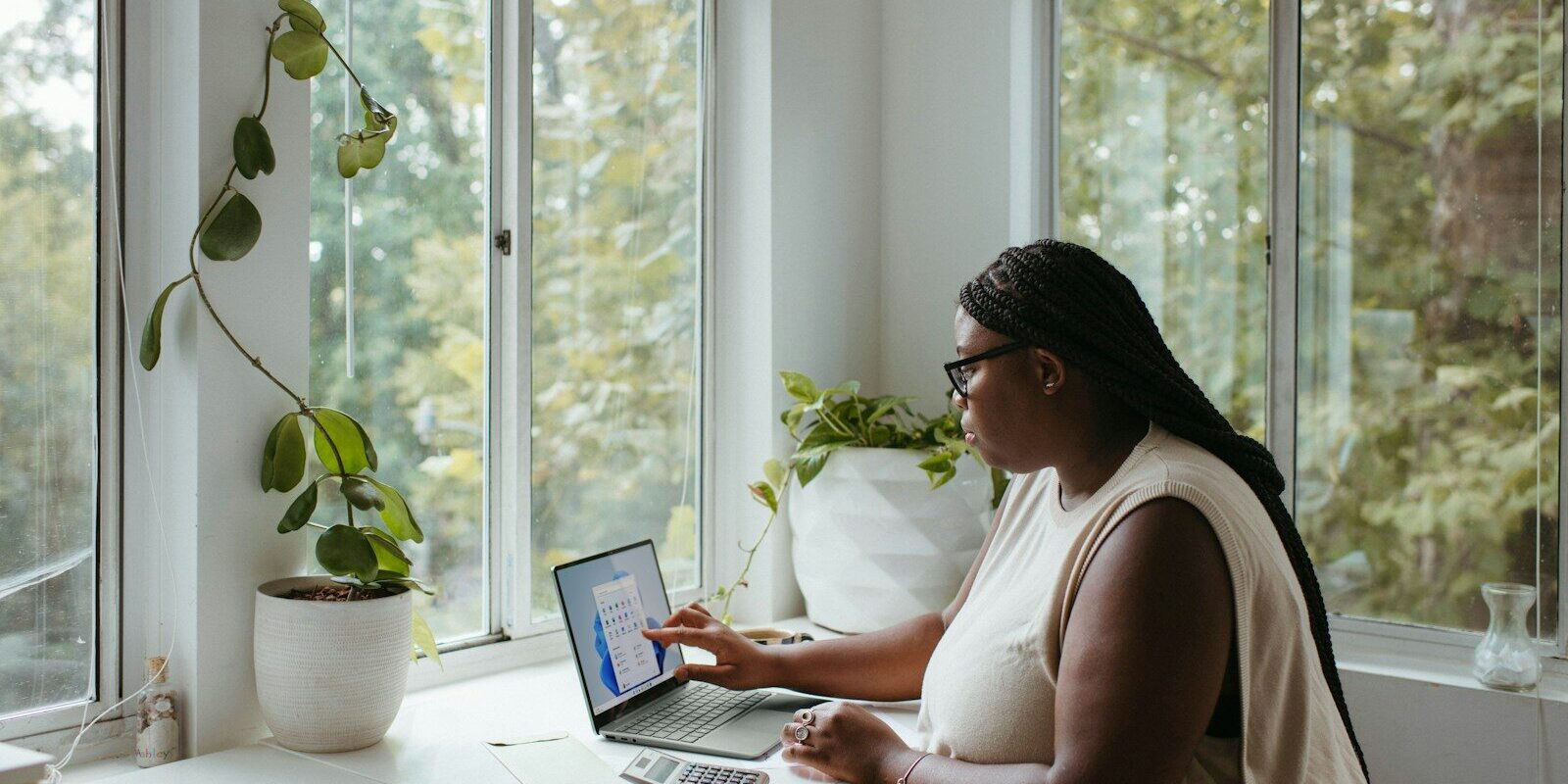 African woman working on a laptop beside a bright window, representing a remote worker on a Kenyan Class N permit